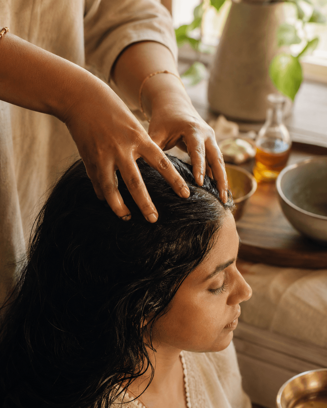 Hands applying hibiscus hair oil as part of a weekly pre-wash ritual